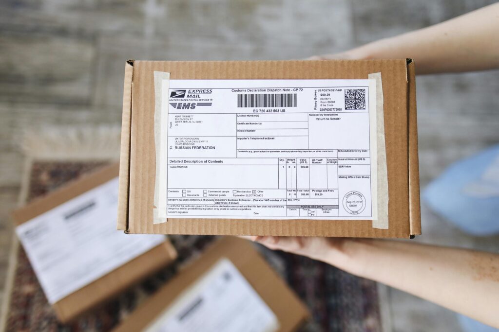 Top view of hands holding an express mail parcel with a customs declaration.