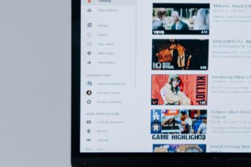 Person browsing YouTube videos on a laptop, showcasing modern technology and online content.